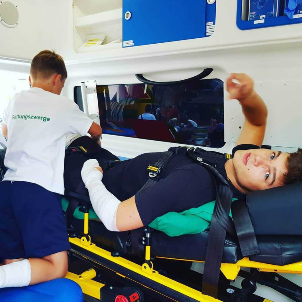Kinder lernen Erste Hilfe in einem Krankenwagen während eines Workshops.