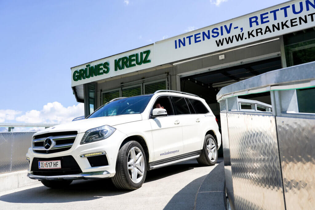 Weißer Krankenwagen vor dem Grünen Kreuz in Zell am See, bereit für medizinische Transporte.