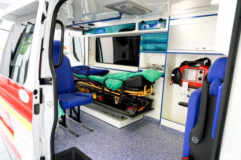 Unutrašnjost modernog vozila za prijevoz pacijenata s ležajem i medicinskom opremom.