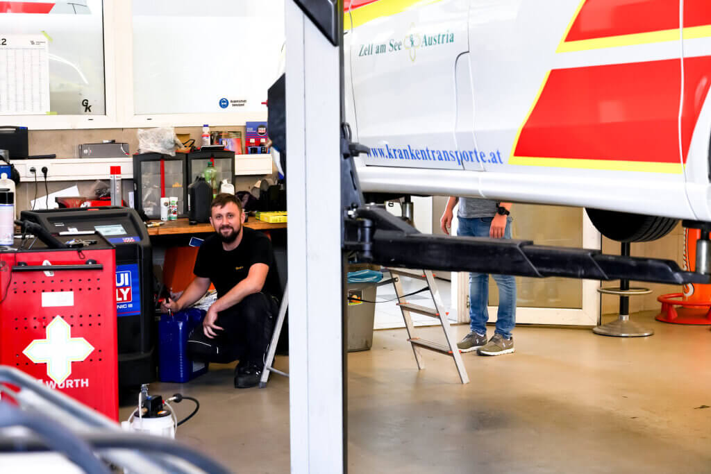 Mechaniker arbeitet in der Werkstatt an einem Krankenwagen des Grünen Kreuzes in Zell am See.